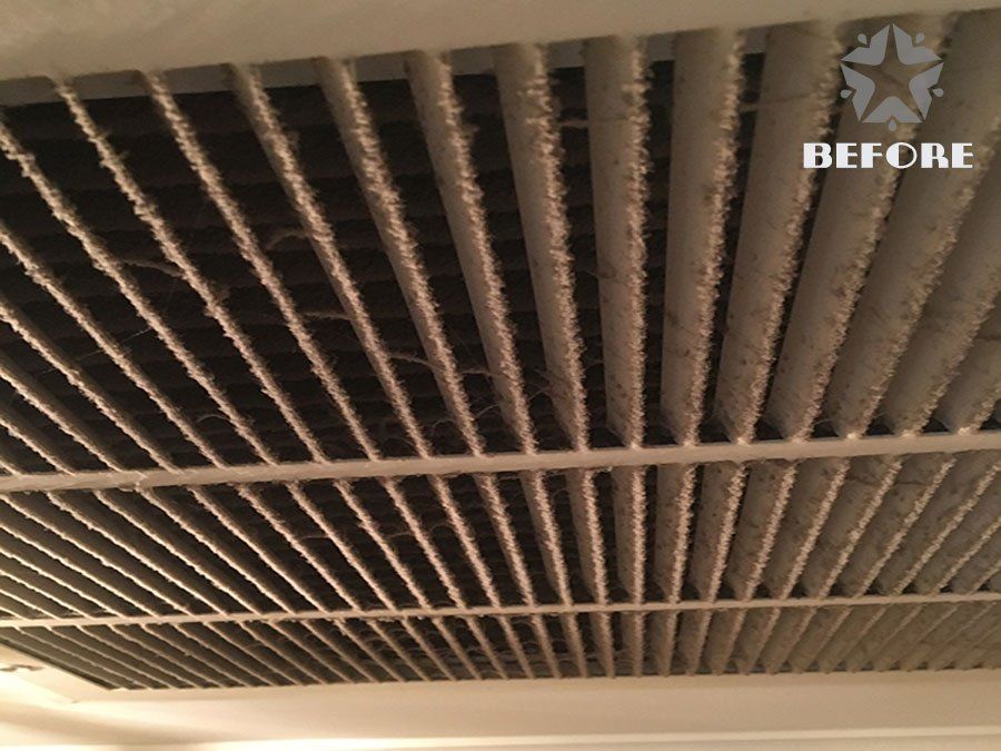 Before photo of a ceiling with dusty vents and a light fixture