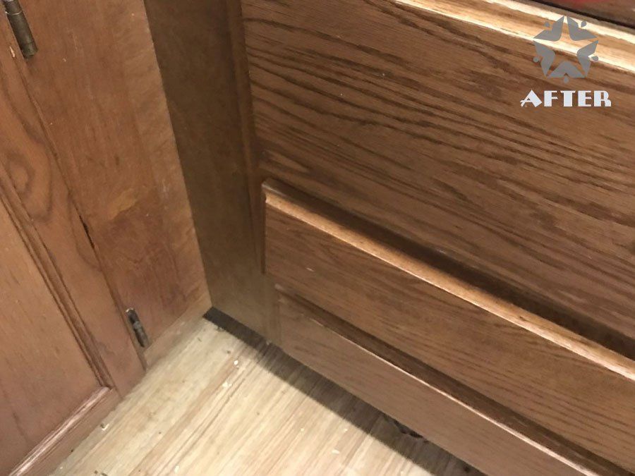 Wooden cabinet corner with a visible gap between two panels and a light wood floor below