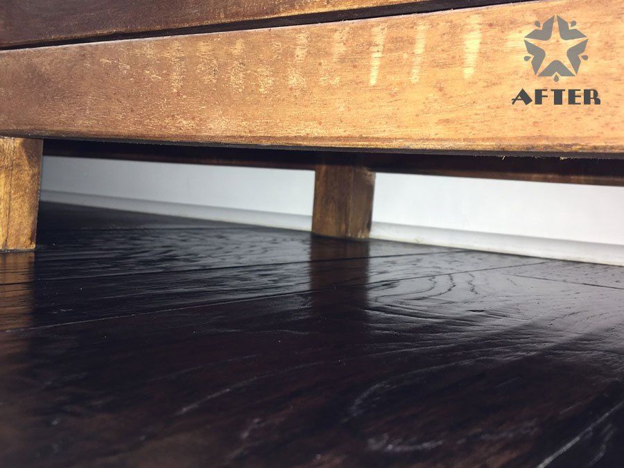 Low-angle view under a wooden bed frame over a dark floor, with the AFTER logo in the top right.
