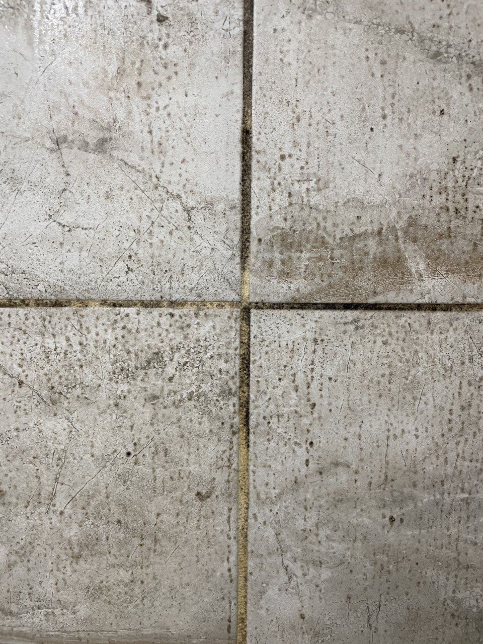 Stained concrete wall with a vertical and horizontal seam forming a cross