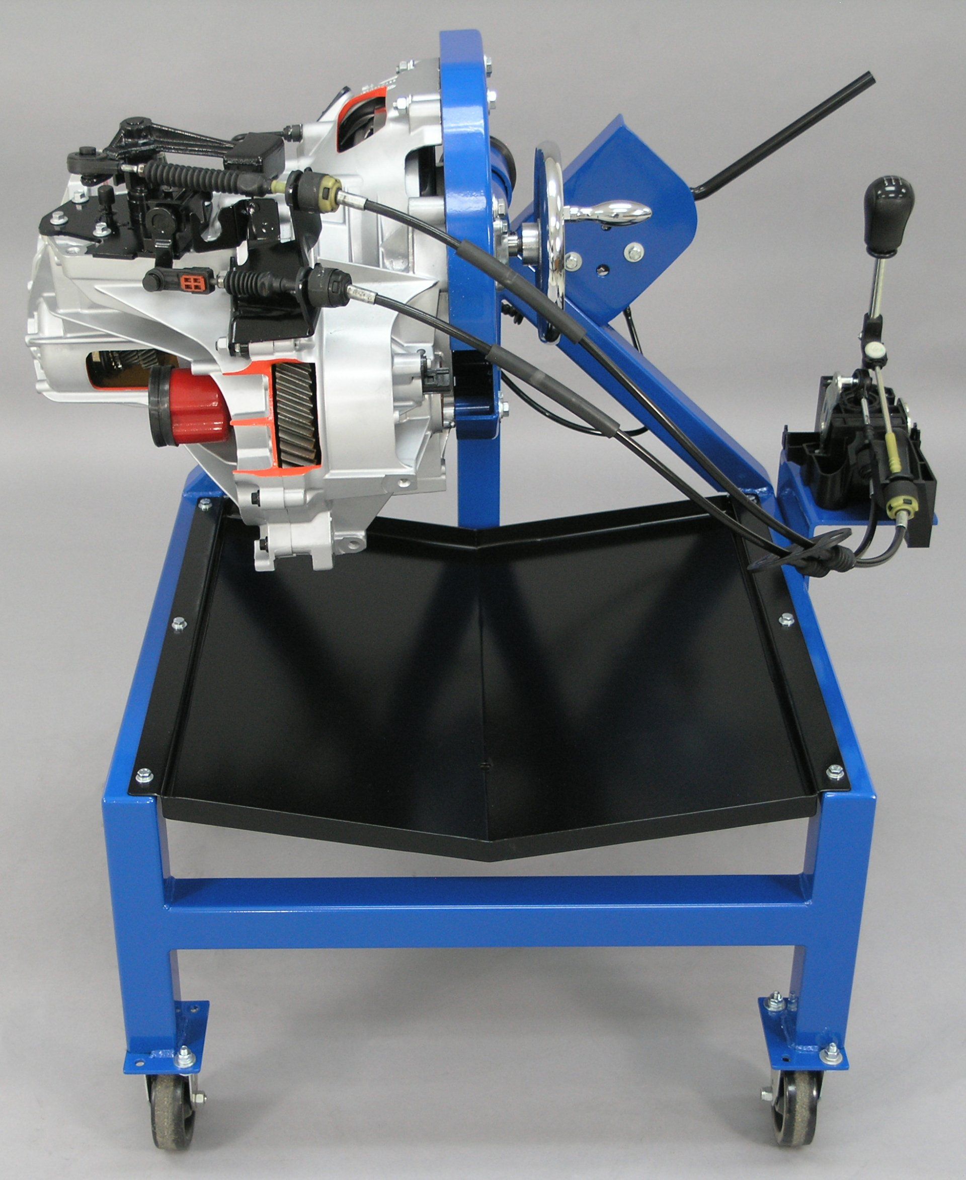A model of a car engine is on a blue cart