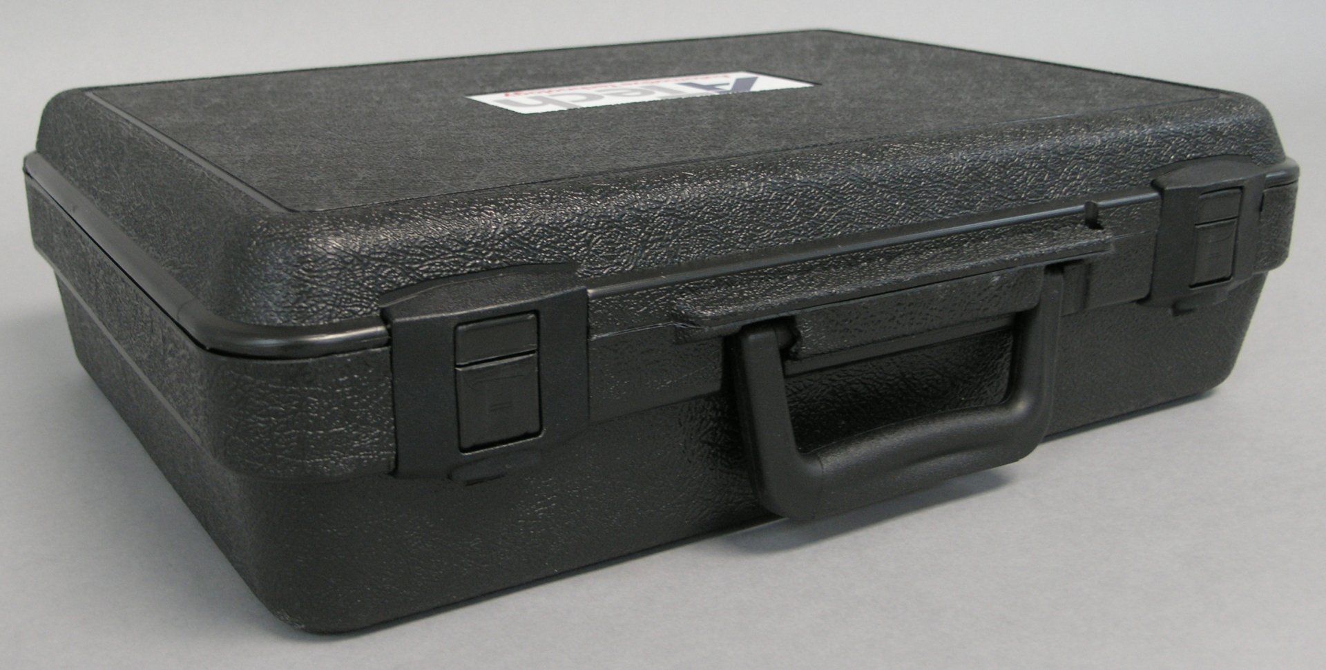 A black plastic briefcase with a handle is sitting on a table.