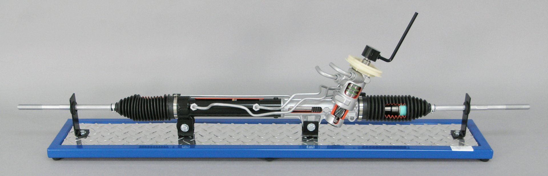 A steering rack is sitting on top of a blue tray on a table.