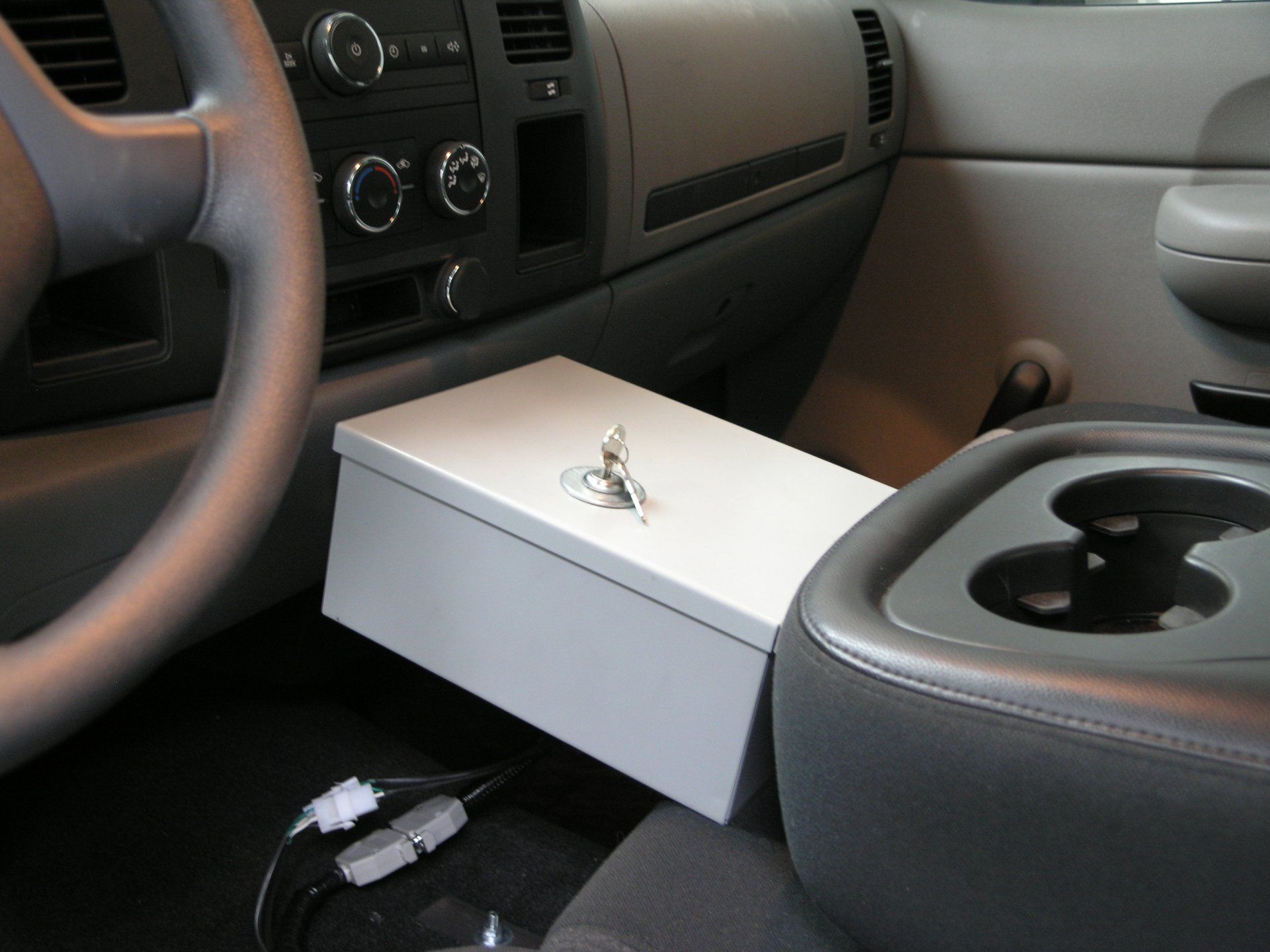 A white box with a key on it sits in a car