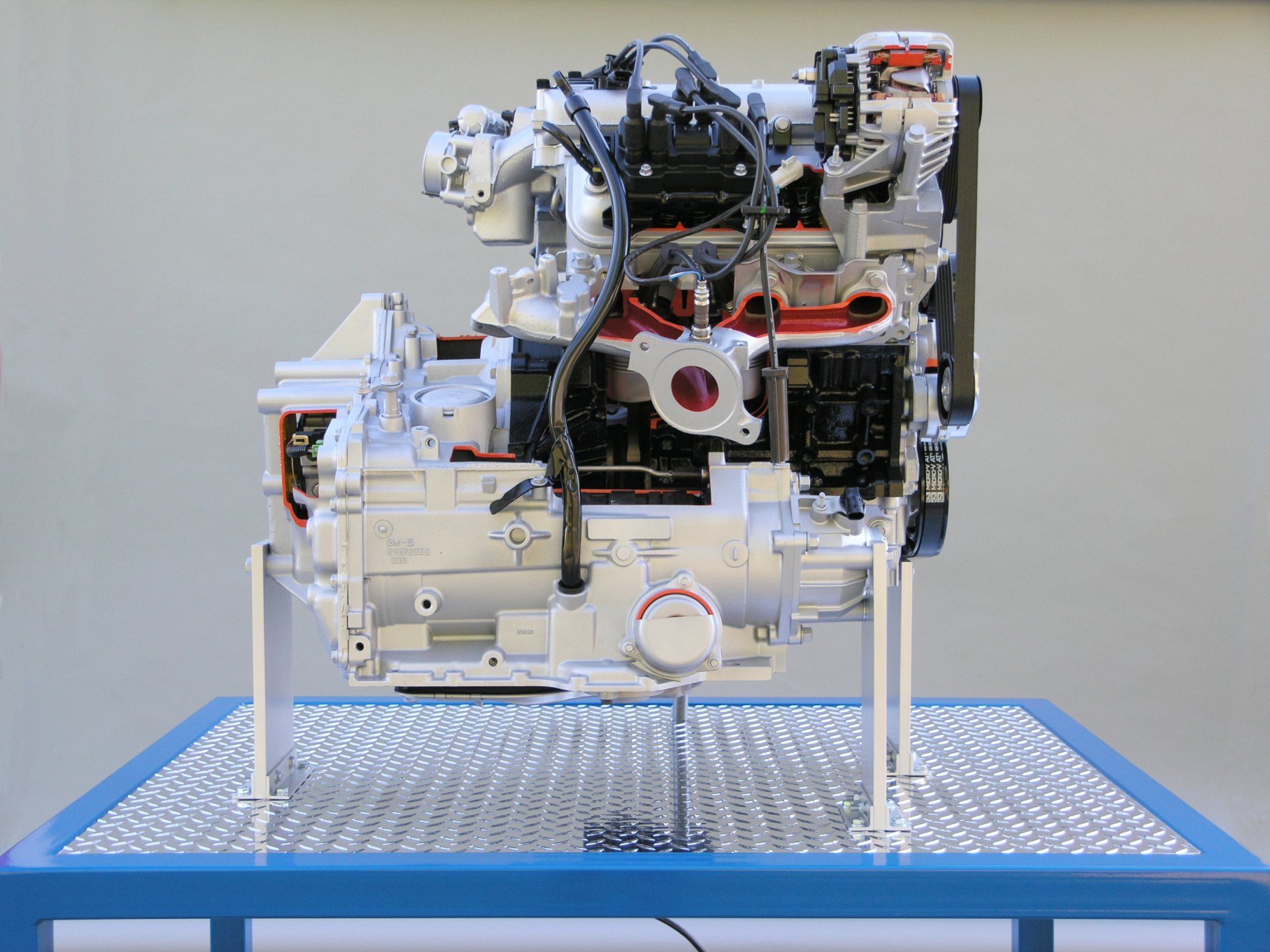 A model of a car engine is sitting on a blue table.