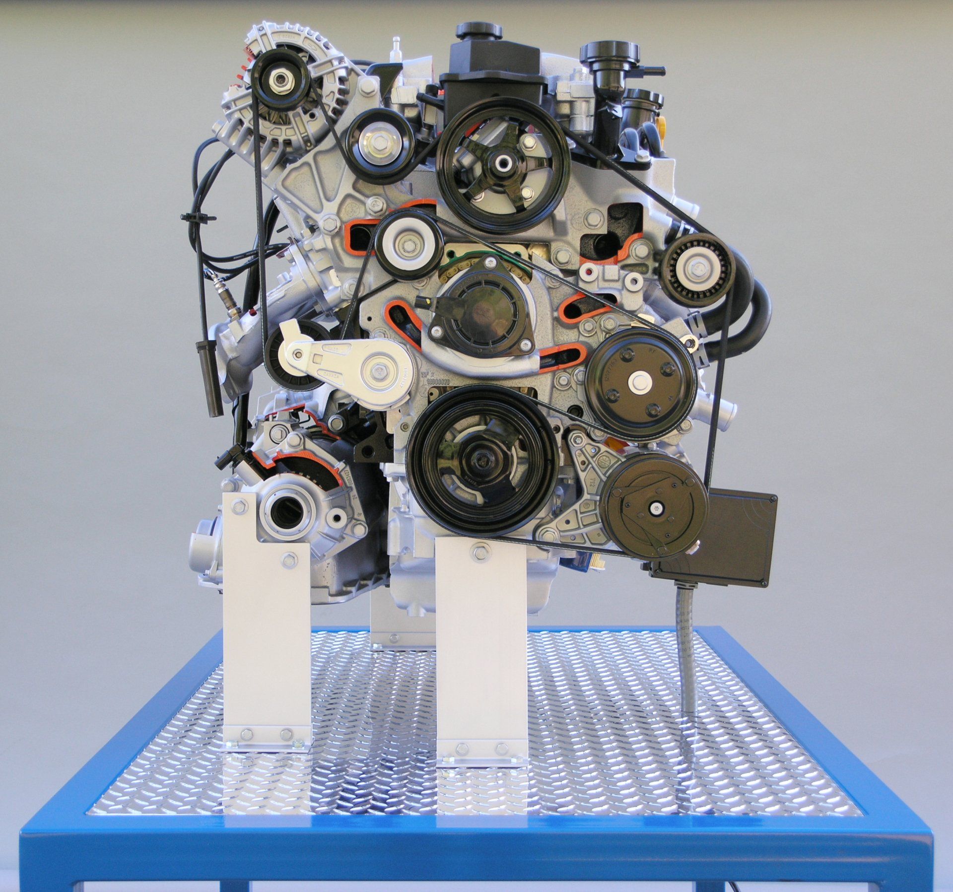 A model of a car engine is sitting on a blue table