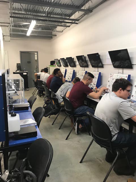 A group of people are sitting at desks in a room