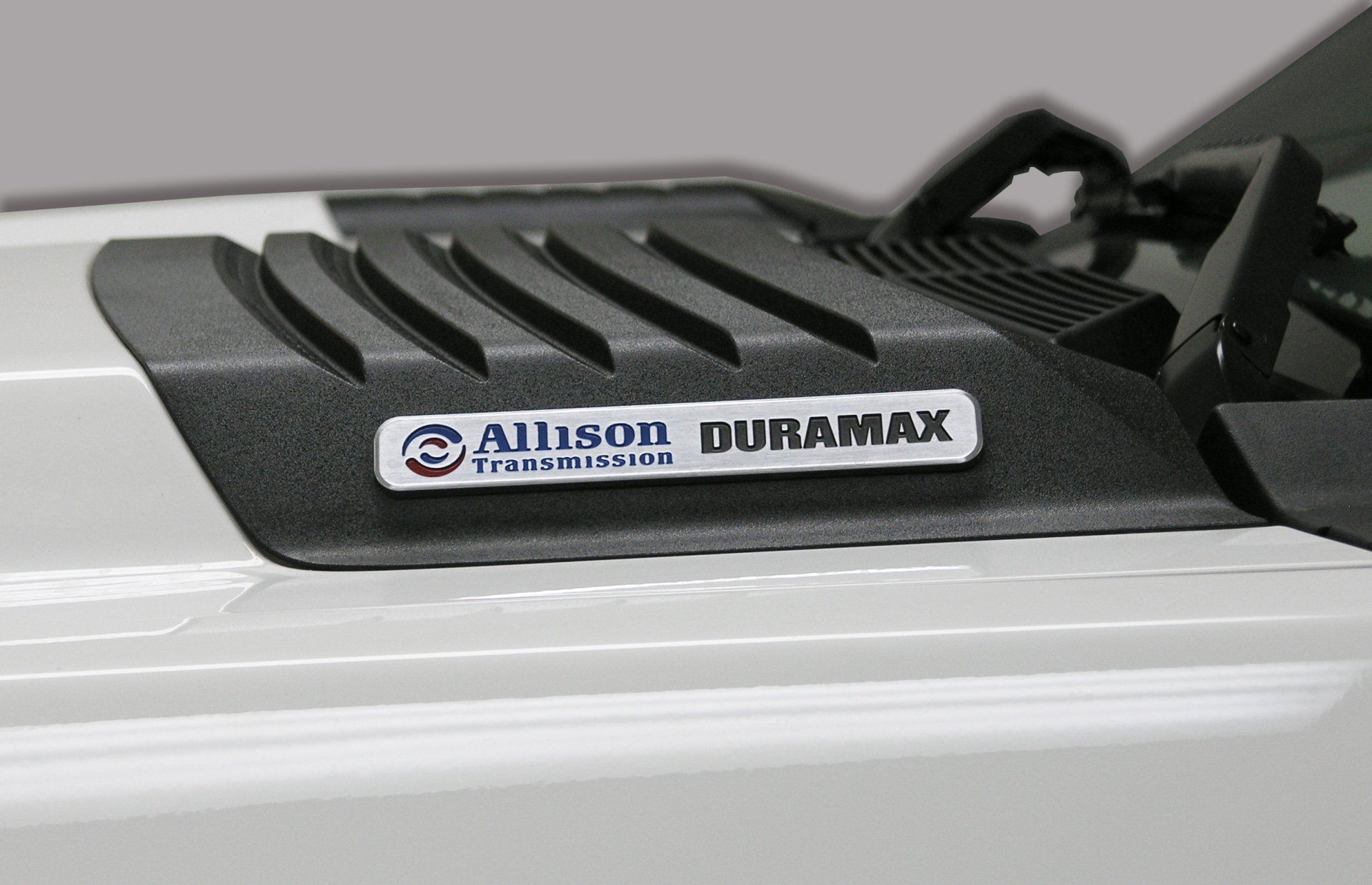 A close up of a white truck with a duramax engine