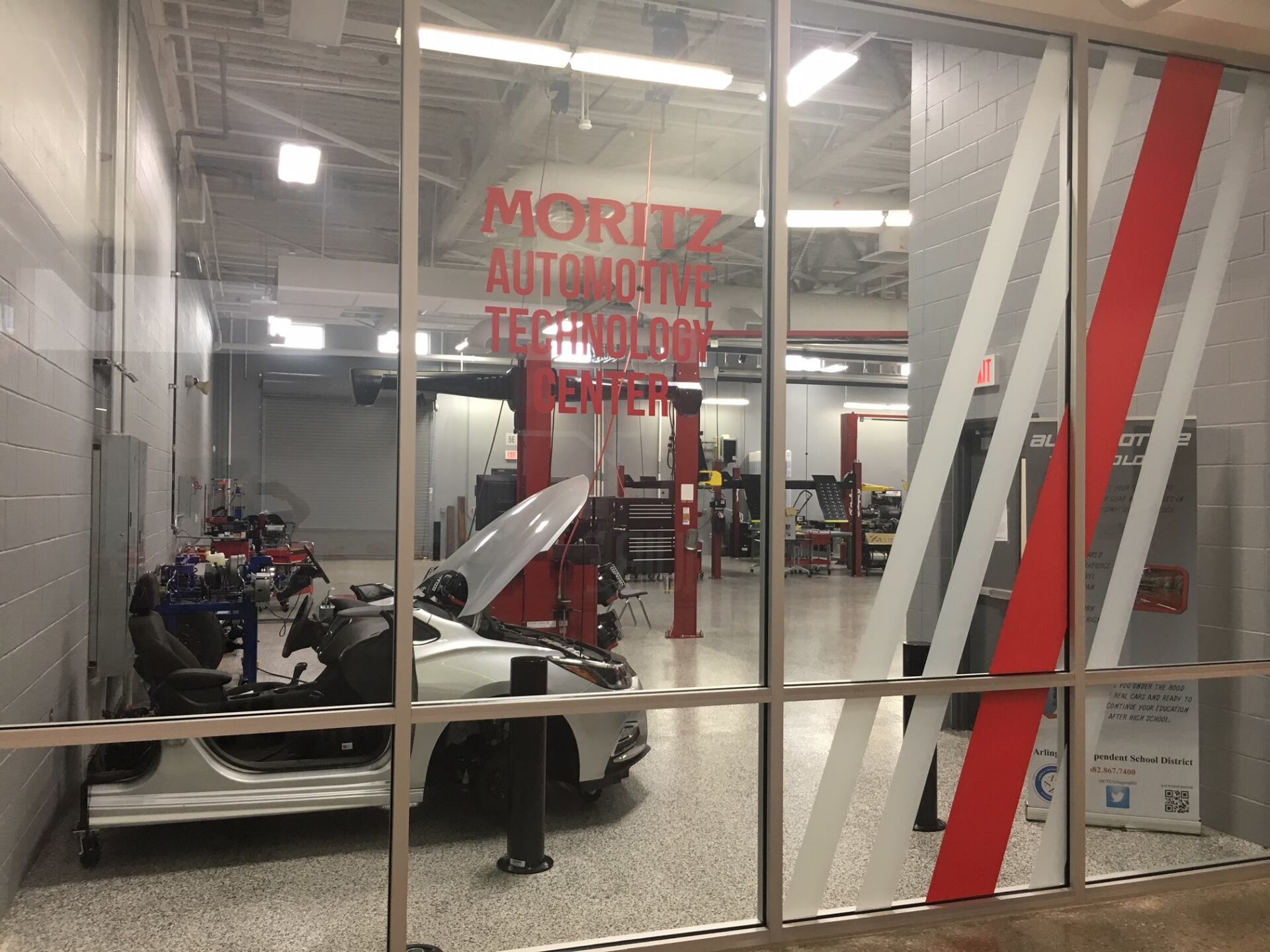 A car is sitting in a garage with the hood open.
