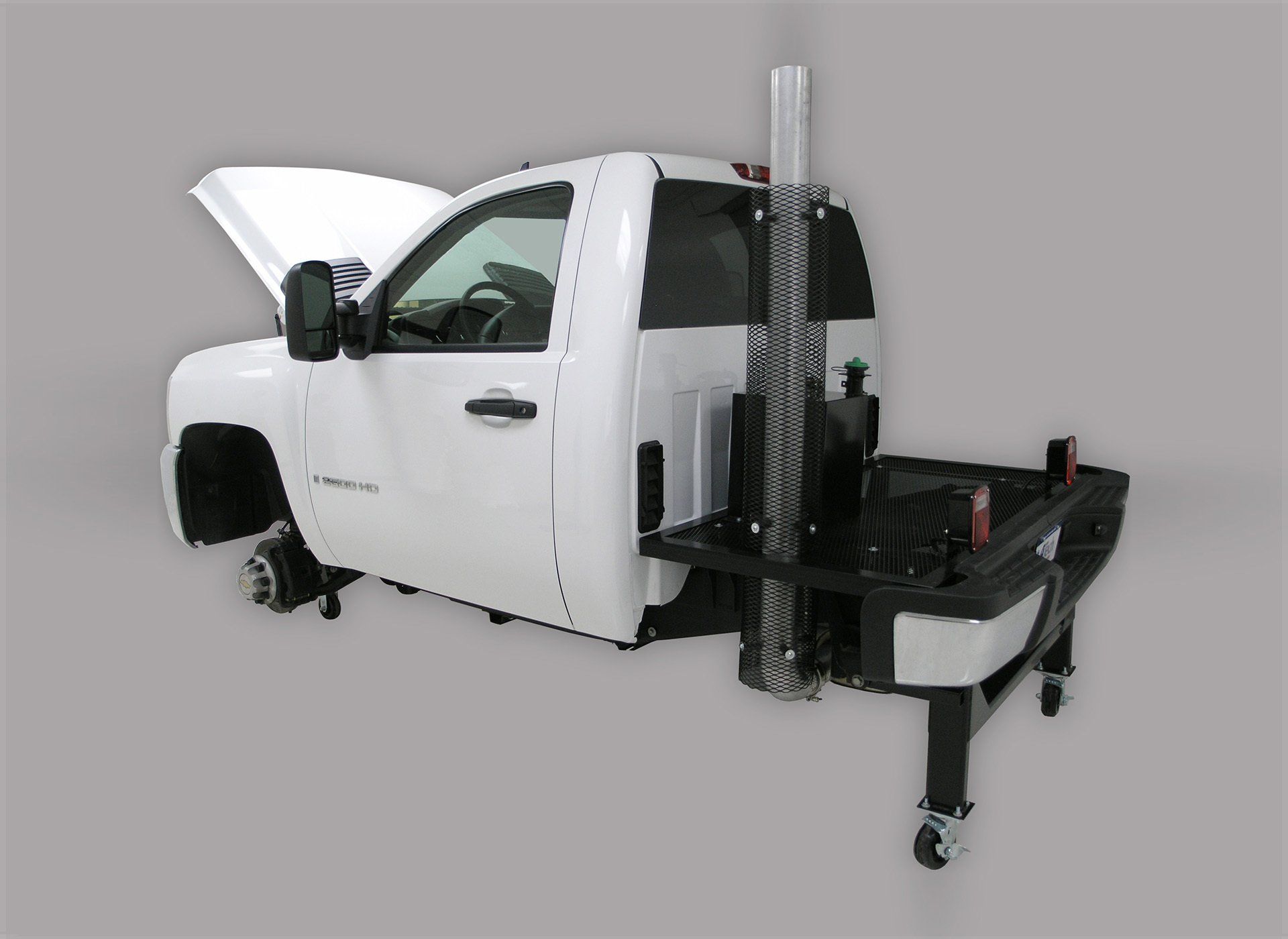 A white truck with the hood open is sitting on a table.