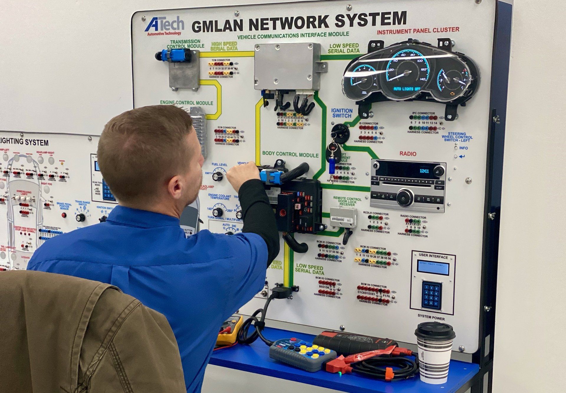 A man is working on a gmlan network system.