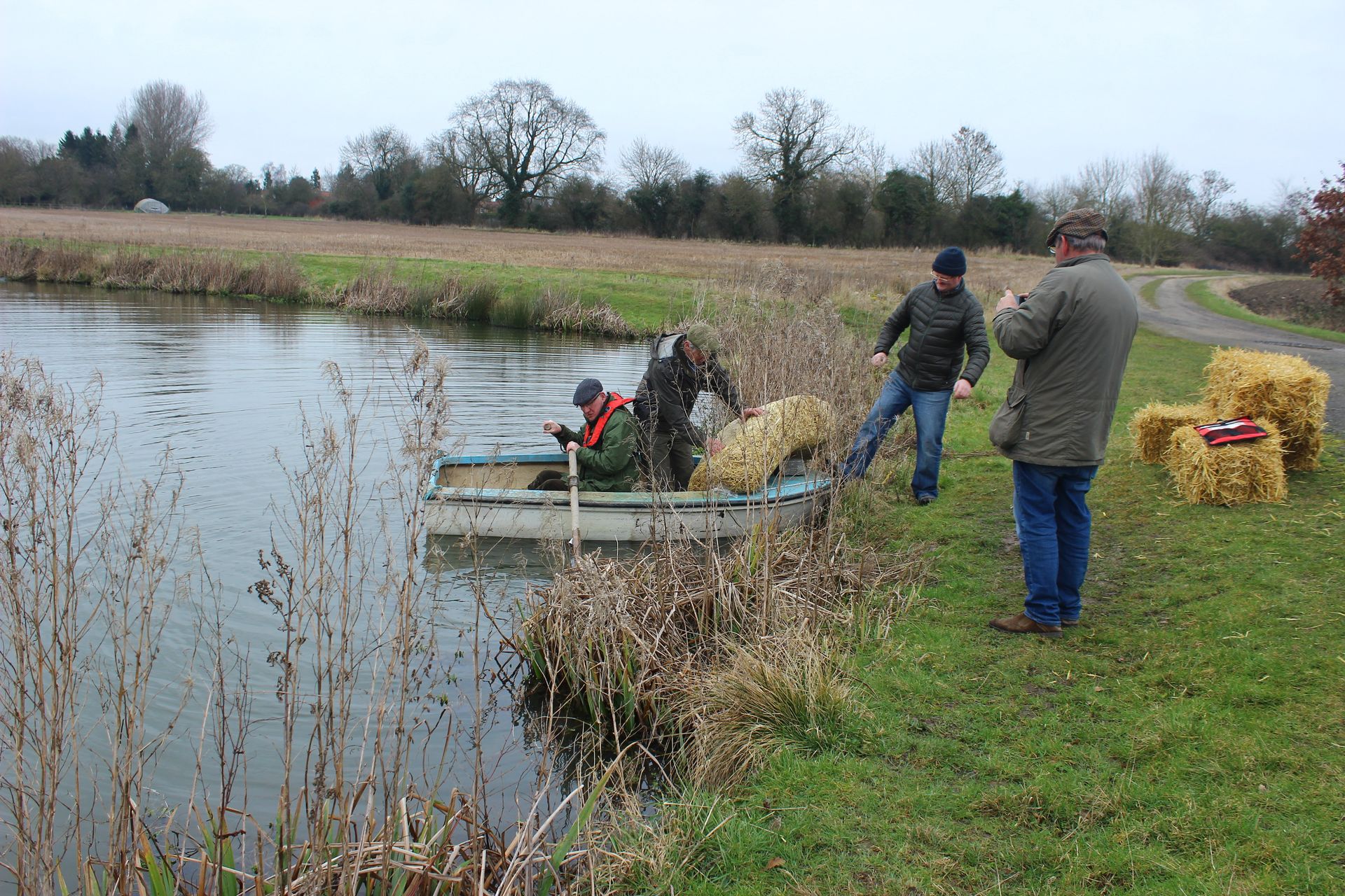 A group of people are standing next to a body of water.