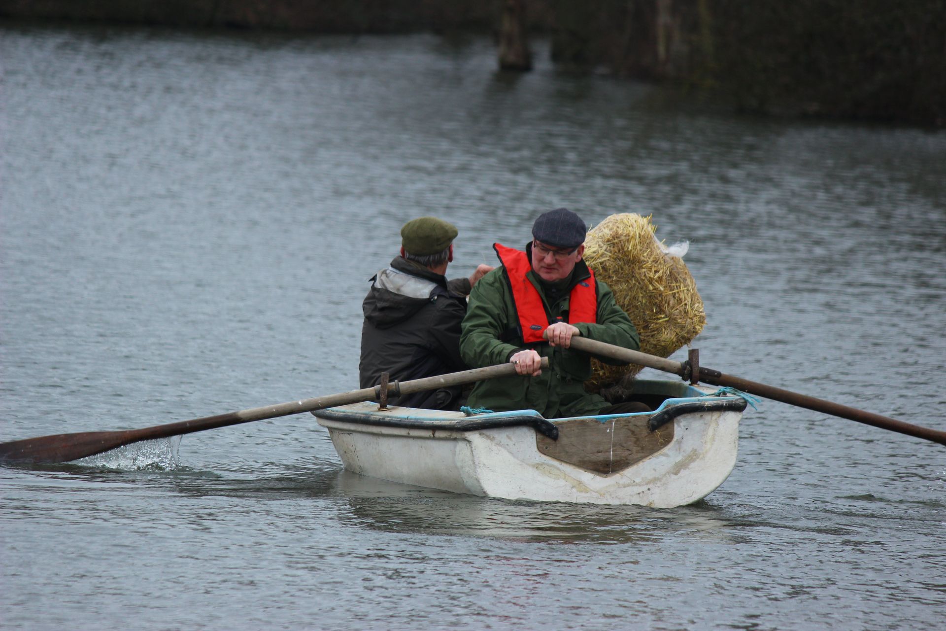 A group of people are rowing a boat on a lake.