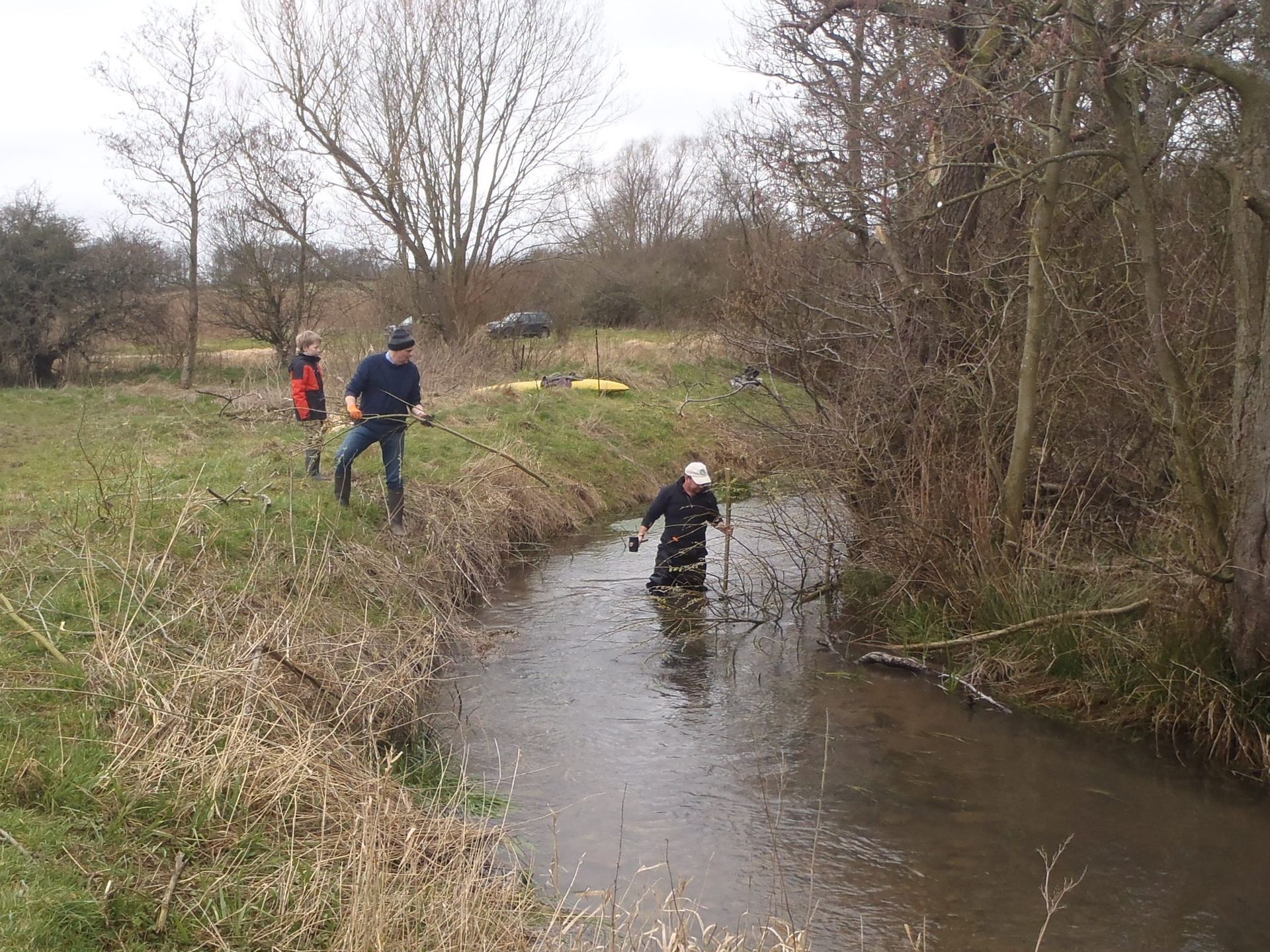 A group of people are standing in a stream.