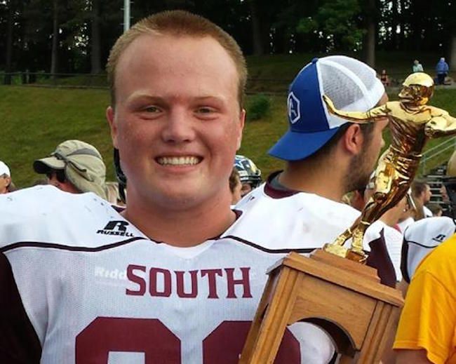 Isaiah Minnich in football uniform holding trophy