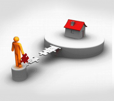 A man is holding a piece of puzzle in front of a house