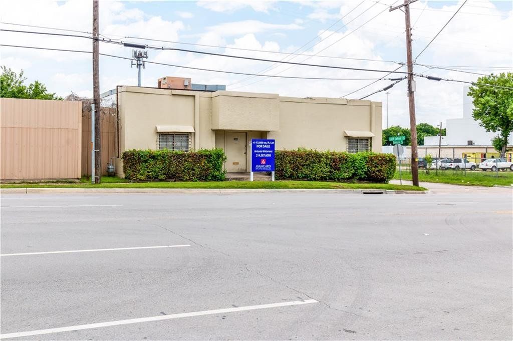 A building with a blue sign in front of it is on the side of the road.