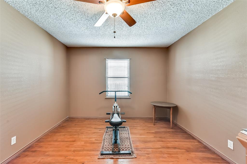 A room with a ceiling fan and a bicycle on the floor