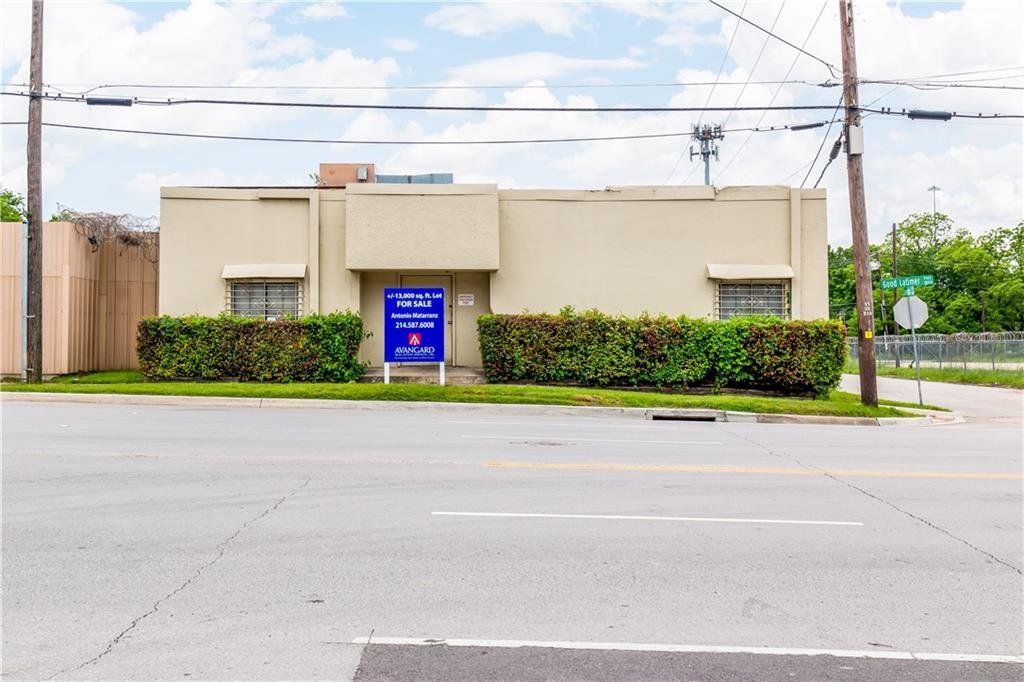 A building with a blue sign in front of it is on the side of the road.