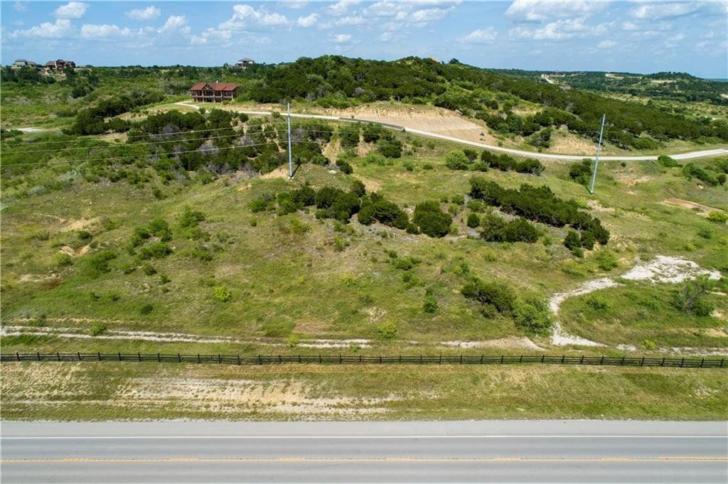 An aerial view of a grassy hillside next to a road.
