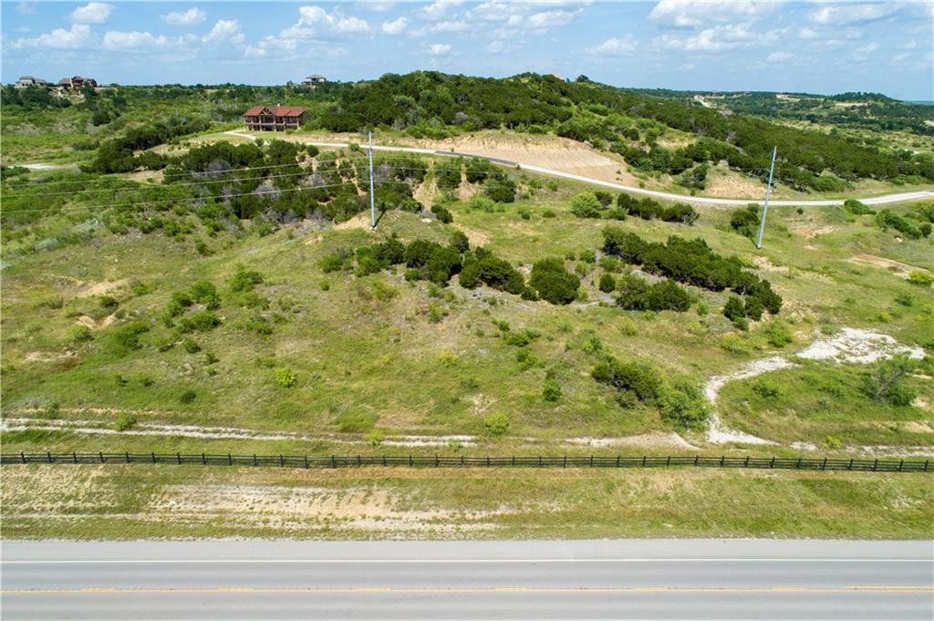 An aerial view of a lush green hillside next to a road.