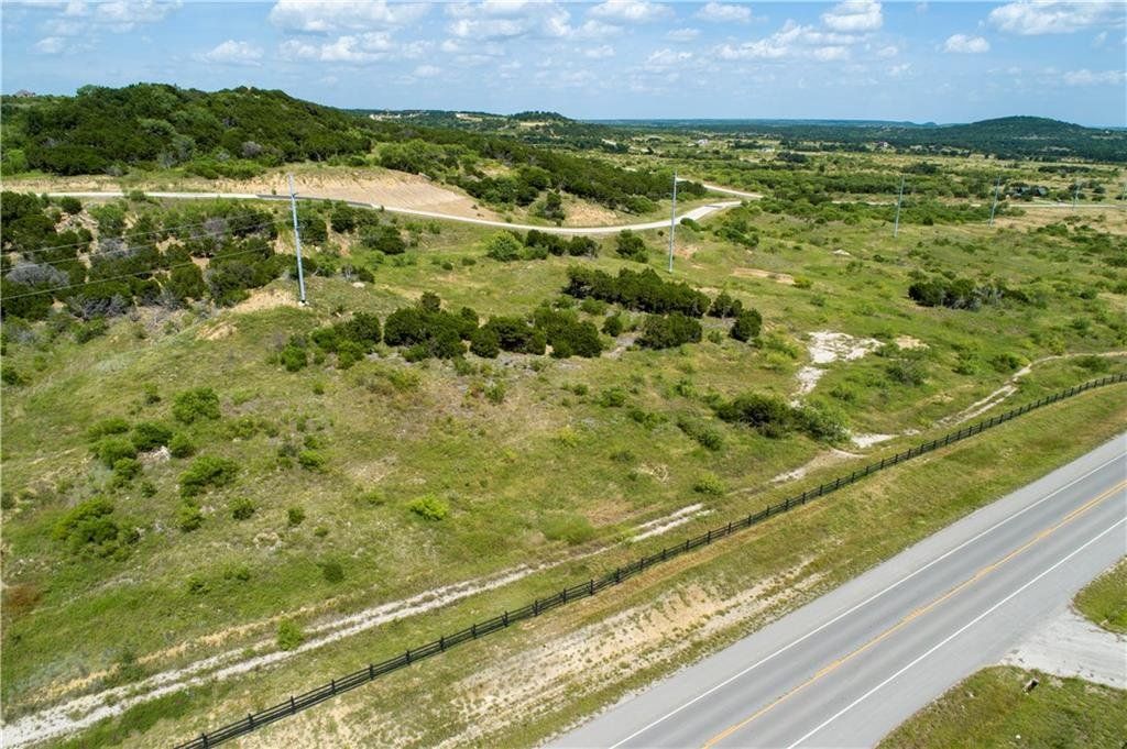 An aerial view of a lush green field next to a highway.