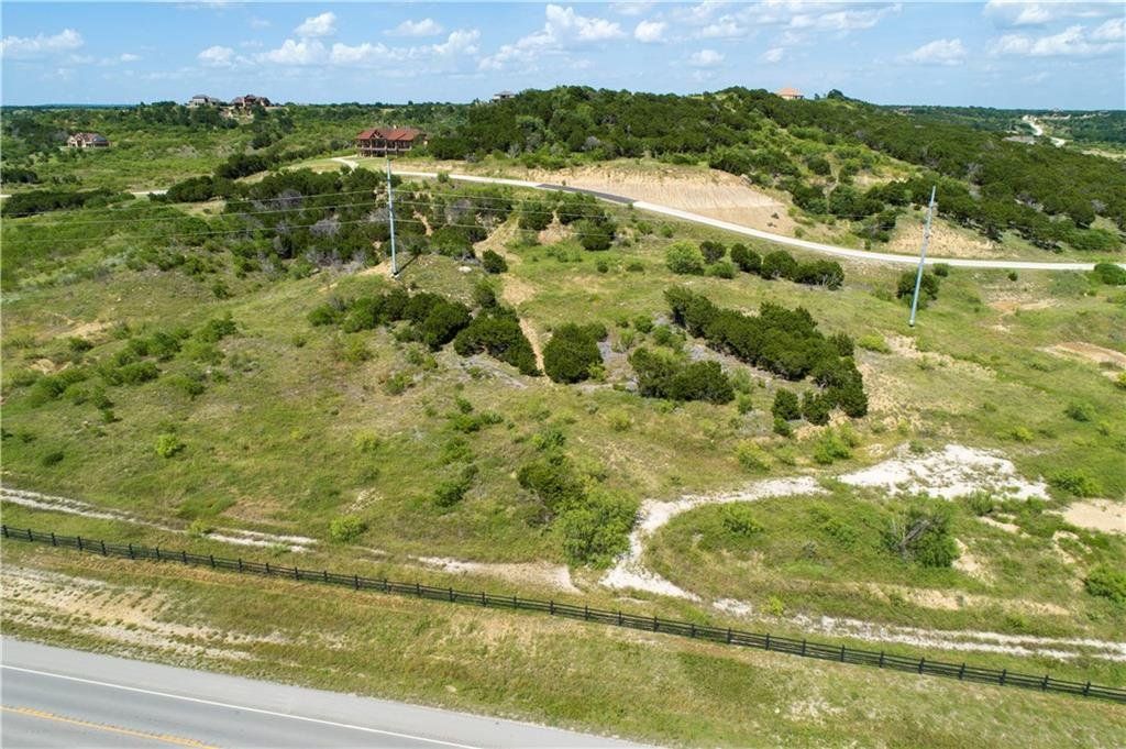 An aerial view of a grassy hillside next to a road.