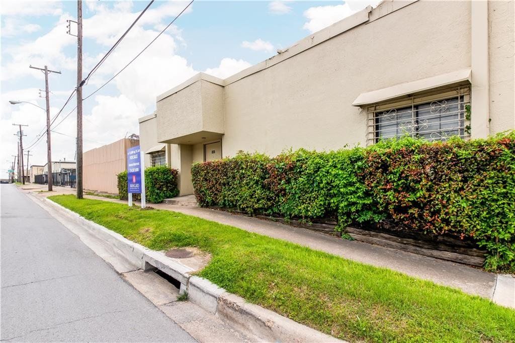 A building with a fence and a sign on the side of the road.