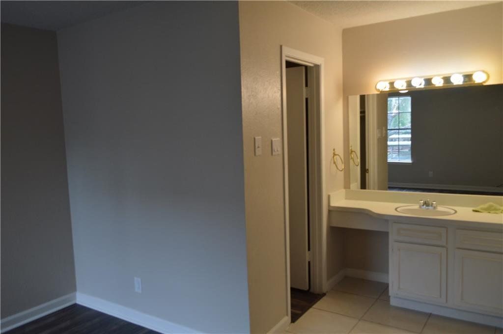 A bathroom with a large mirror and a sink