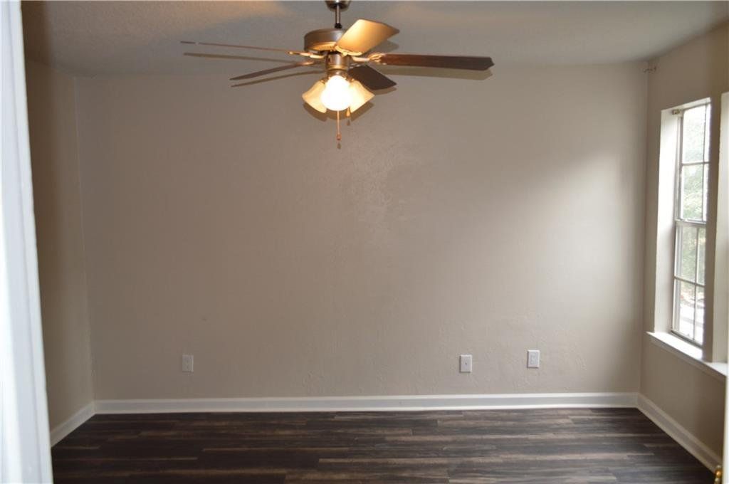 An empty room with a ceiling fan and a window