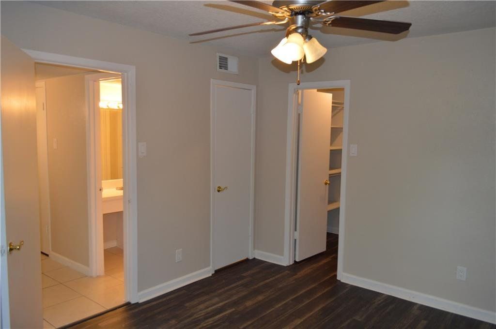An empty bedroom with a ceiling fan and a bathroom
