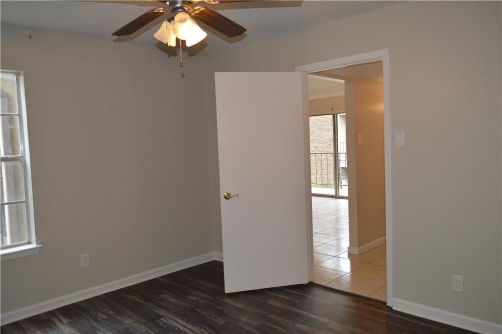 An empty room with a ceiling fan and a door open.