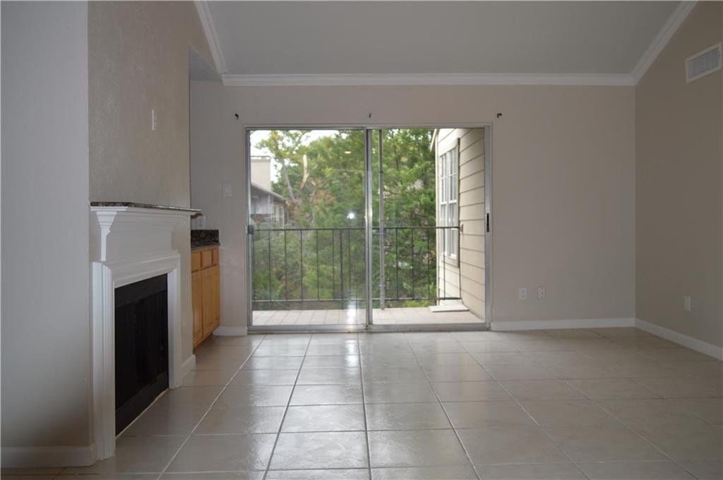 An empty living room with a fireplace and sliding glass doors