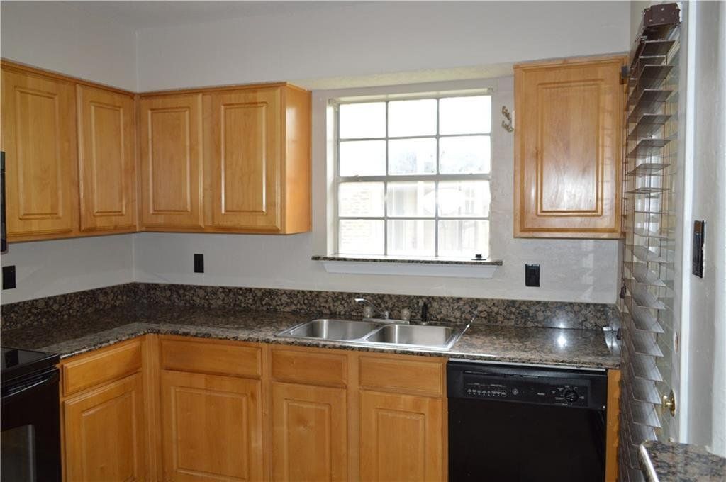 A kitchen with wooden cabinets and granite counter tops