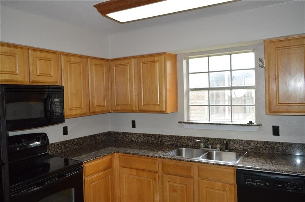 A kitchen with wooden cabinets and granite counter tops