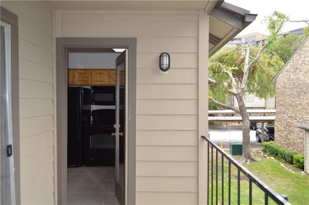 A balcony with a sliding glass door leading to a kitchen