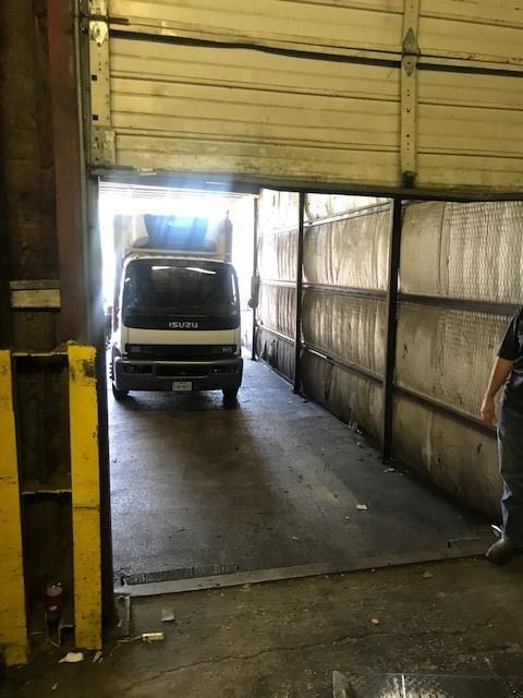A white truck is parked in a garage doorway.