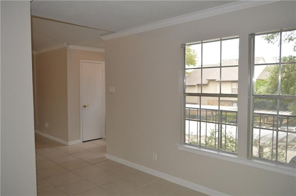 An empty room with two windows and a door