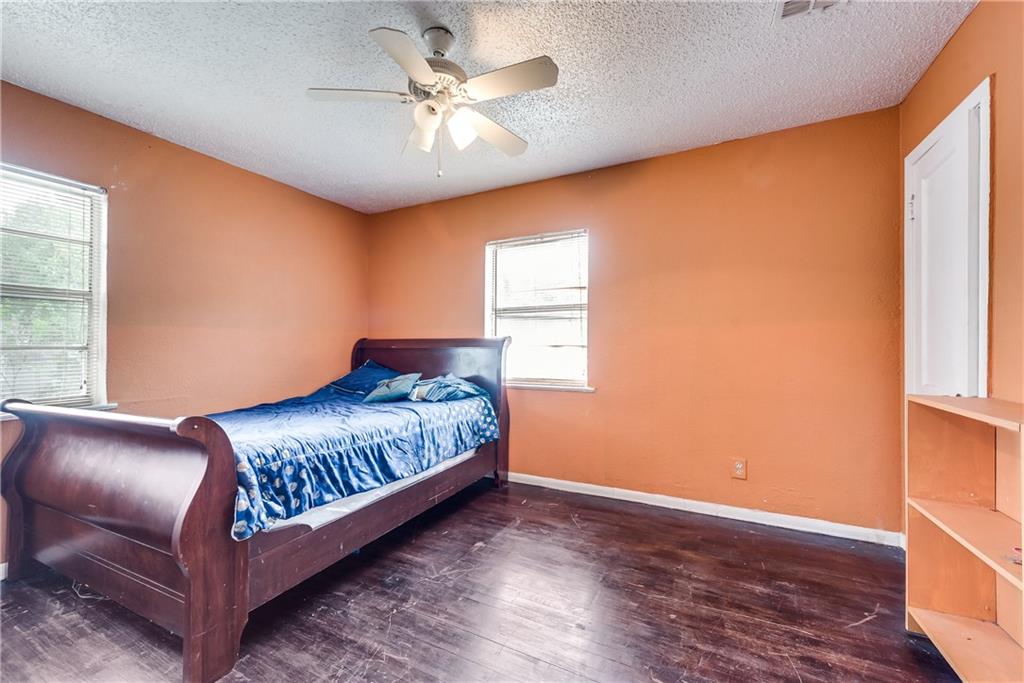 A bedroom with a sleigh bed and a ceiling fan.