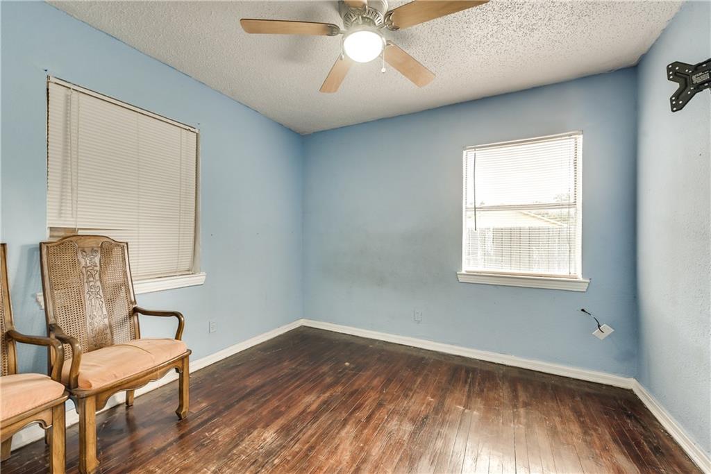 An empty room with two chairs and a ceiling fan