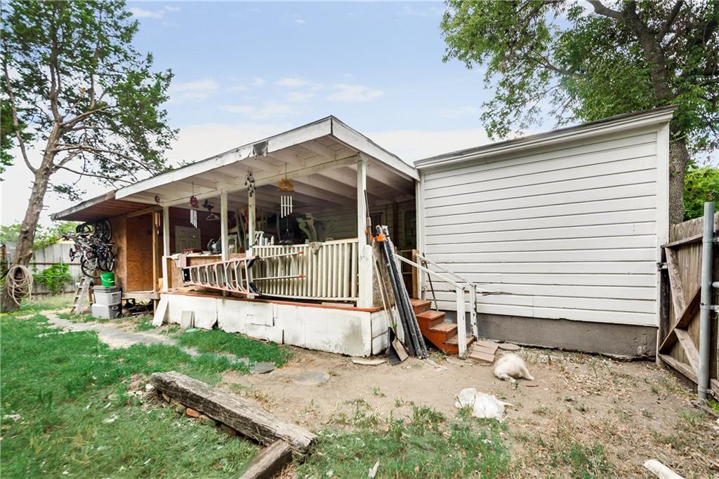 A mobile home with a porch and stairs in the backyard.