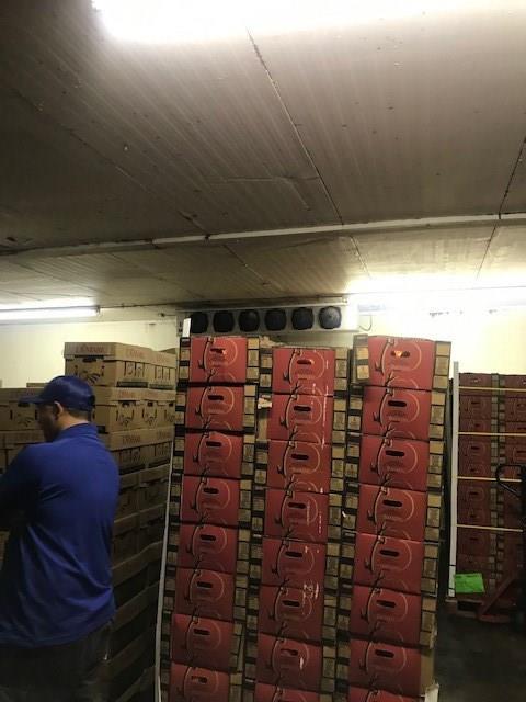 A man in a blue shirt is working in a warehouse filled with boxes