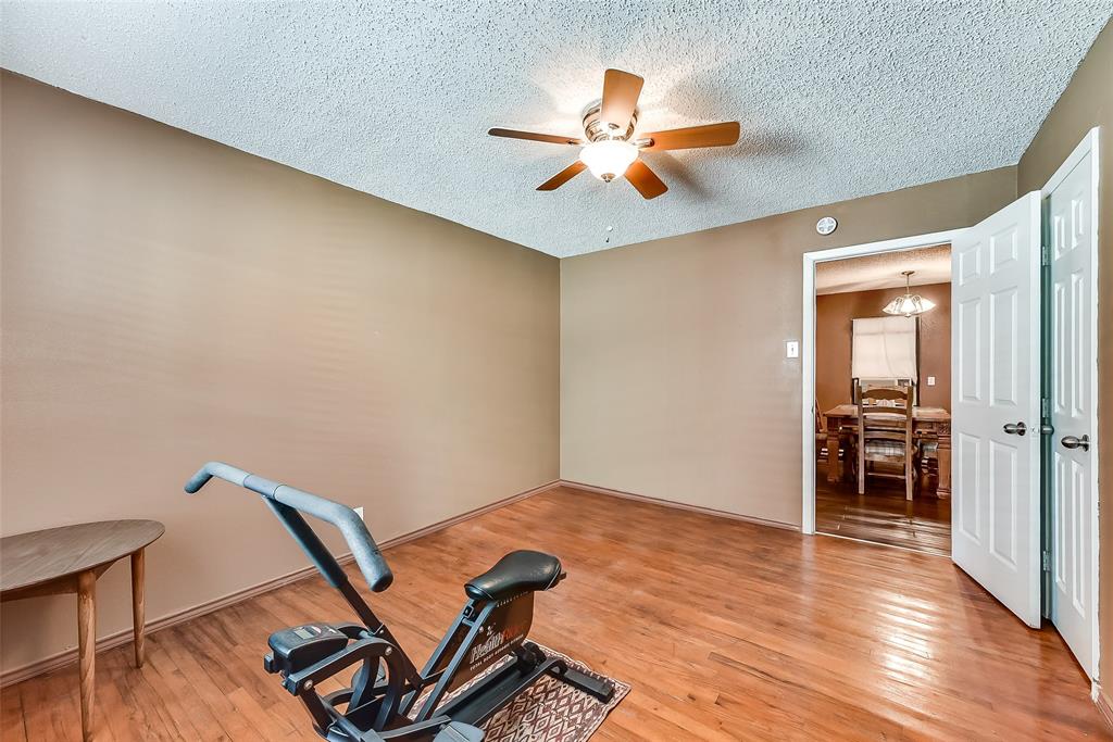 A room with hardwood floors and a ceiling fan.