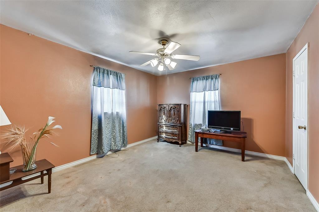 A living room with a ceiling fan and a flat screen tv.
