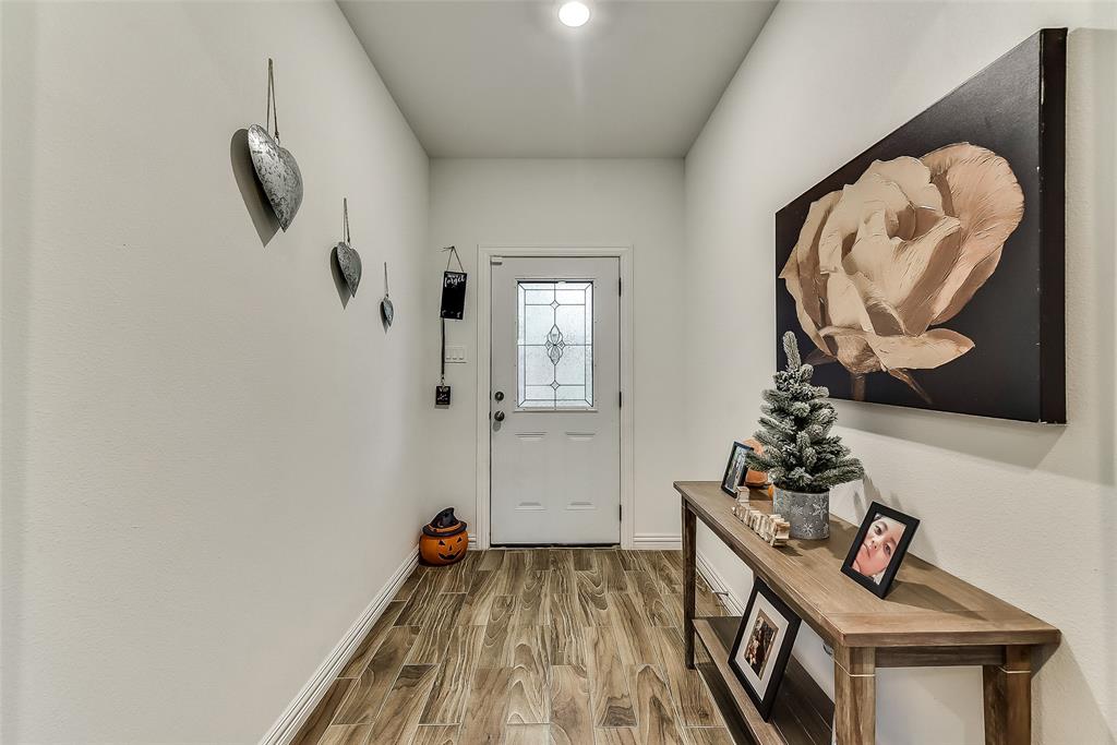 A hallway with a table and a painting on the wall.