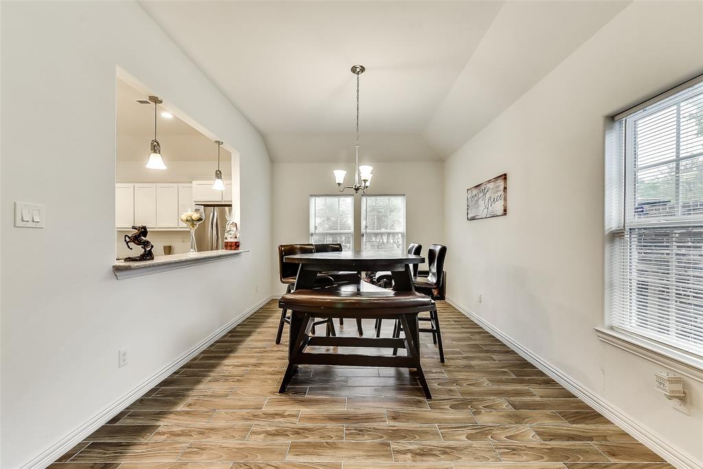 A dining room with a wooden table and chairs