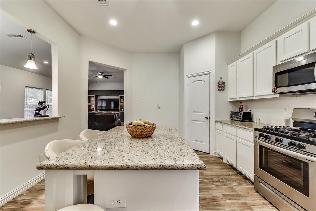 A kitchen with granite counter tops , stainless steel appliances , and a large island.