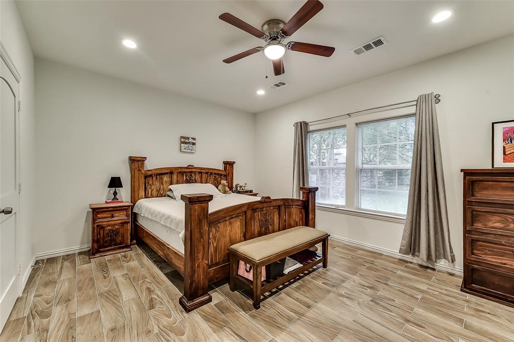 A bedroom with a wooden bed and a ceiling fan.