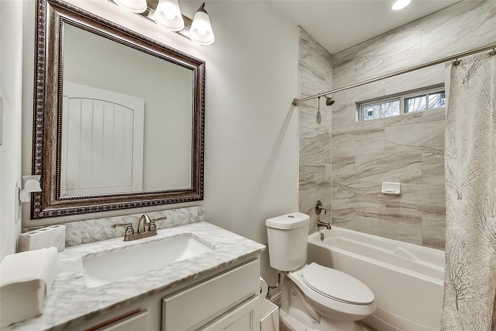 A bathroom with a sink , toilet , tub and mirror.
