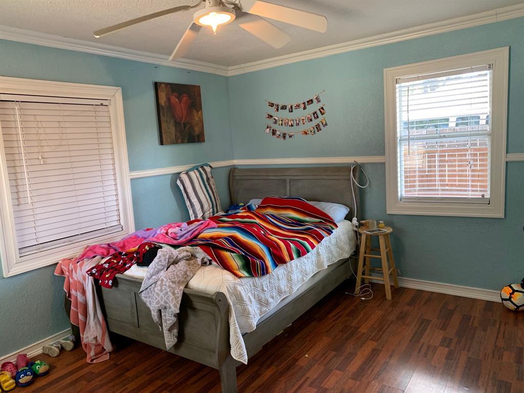 A bedroom with a bed and a ceiling fan.